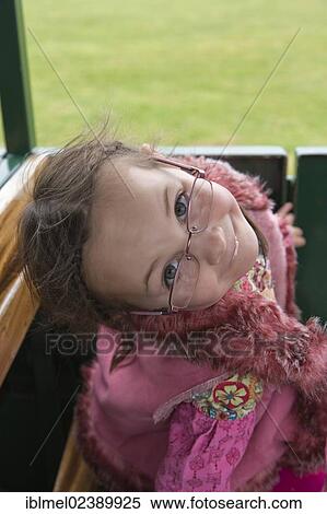 Stock Photography - 5 years old girl peeking over her glasses. Fotosearch