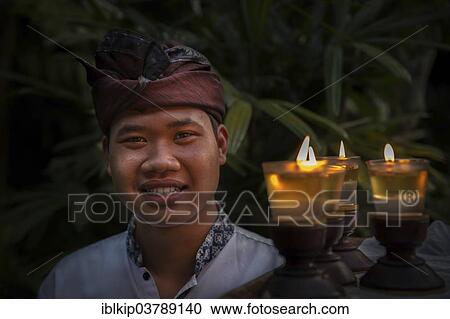 "A Balinese man in traditional clothing carrying candles, Ubud, Bali, Indonesia, Asia" View Large Photo Image Stock Image - "A Balinese man in traditional clothing carrying candles, Ubud, Bali, Indonesia, Asia". Fotosearch