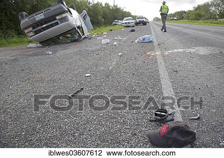 Stock Image - "A baseball cap lying on the road after a van holding 26 undocumented immigrants from Central America overturned on Texas Highway 285, Falfurrias, Texas, United States, North America". Fotosearch