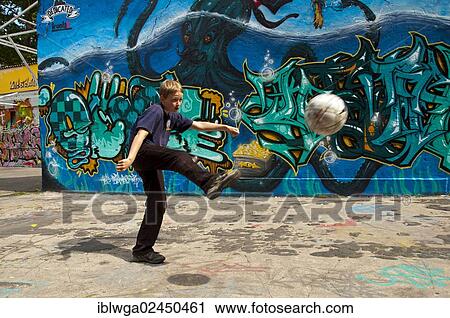 "A boy, 10 years, is playing with his football in front of a graffiti covered wall, football ground, Cologne, North Rhine-Westphalia, Germany, Europe, PublicGround, Europe" View Large Photo Image Stock Image - "A boy, 10 years, is playing with his football in front of a graffiti covered wall, football ground, Cologne, North Rhine-Westphalia, Germany, Europe, PublicGround, Europe". Fotosearch