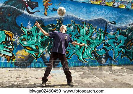 "A boy, 10 years, is playing with his football in front of a graffiti covered wall, football ground, Cologne, North Rhine-Westphalia, Germany, Europe, PublicGround, Europe" View Large Photo Image Stock Photo - "A boy, 10 years, is playing with his football in front of a graffiti covered wall, football ground, Cologne, North Rhine-Westphalia, Germany, Europe, PublicGround, Europe". Fotosearch