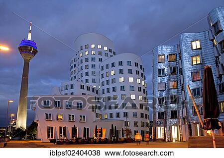 "A building by American architect Frank O. Gehry and the Rheinturm tower at night, Neuer Zollhof building complex, Medienhafen district, Duesseldorf, North Rhine-Westphalia, Germany, Europe" View Large Photo Image Stock Photo - "A building by American architect Frank O. Gehry and the Rheinturm tower at night, Neuer Zollhof building complex, Medienhafen district, Duesseldorf, North Rhine-Westphalia, Germany, Europe". Fotosearch
