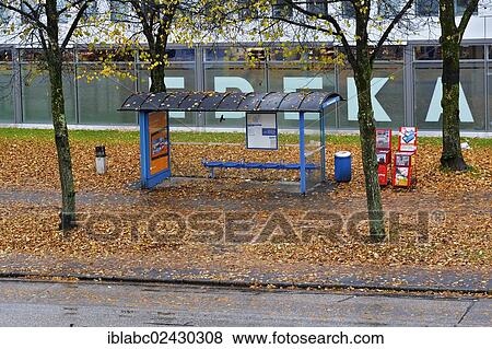 Stock Photo - "A bus stop surrounded by autumn foliage in the rain, Harlaching, Munich, Bavaria, Germany, Europe". Fotosearch