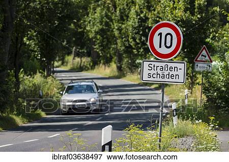 "A car travelling on the L657 road, speed limit sign of 10km h, due to road damage, Mengede, Dortmund, Ruhr district, North Rhine-Westphalia, Germany, Europe" View Large Photo Image Stock Photo - "A car travelling on the L657 road, speed limit sign of 10km h, due to road damage, Mengede, Dortmund, Ruhr district, North Rhine-Westphalia, Germany, Europe". Fotosearch