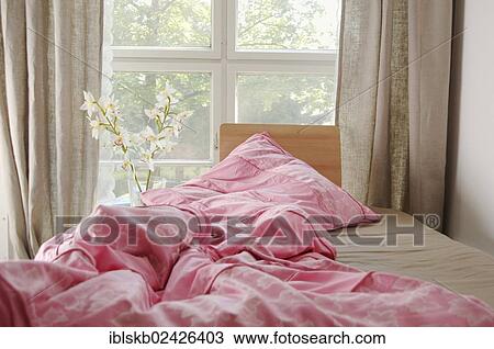 A crumpled bed with a pink blanket by a window View Large Photo Image Stock Image - A crumpled bed with a pink blanket by a window. Fotosearch