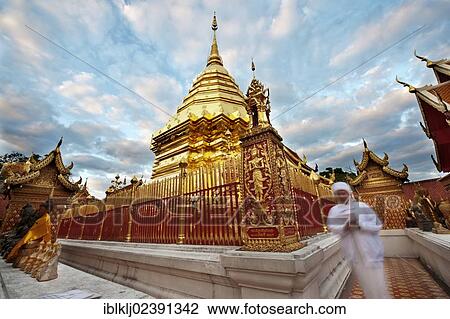 Stock Image - "A devotee prays at Wat Doi Suthep Buddhist temple, Chiang Mai, Thailand, Asia". Fotosearch