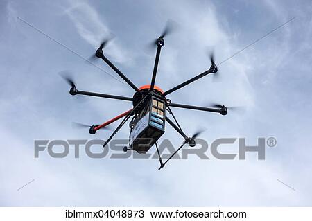 Stock Image - "A drone carrying a package, Germany, Europe". Fotosearch