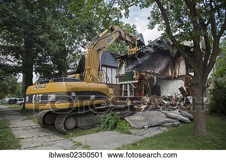 Stock Image - "A fire-damaged and vacant home in the Morningside neighborhood is demolished, Detroit, Michigan, USA". Fotosearch