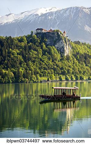 "A flat bottomed boat called Pletna on Lake Bled with Bled Castle and the alps at the back, Bled, Slovenia, Europe" View Large Photo Image Stock Photo - "A flat bottomed boat called Pletna on Lake Bled with Bled Castle and the alps at the back, Bled, Slovenia, Europe". Fotosearch