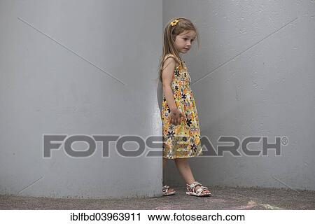 Stock Image - "A girl, 3 years, wearing a dress, standing between walls, Germany, Europe". Fotosearch