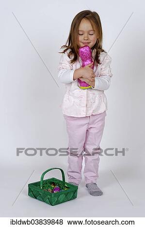 A girl with an Easter basket is embracing a chocolate Easter bunny View Large Photo Image Stock Photo - A girl with an Easter basket is embracing a chocolate Easter bunny. Fotosearch