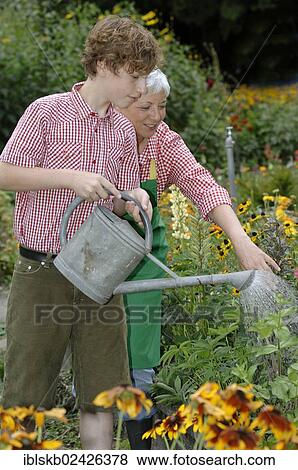 A grandmother is working with her grandson in the garden View Large Photo Image Stock Photo - A grandmother is working with her grandson in the garden. Fotosearch