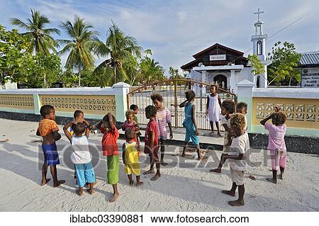 Stock Image - "A group of children standing in front of a church, Arborek, Raja Ampat, West Papua, Indonesia, Asia". Fotosearch