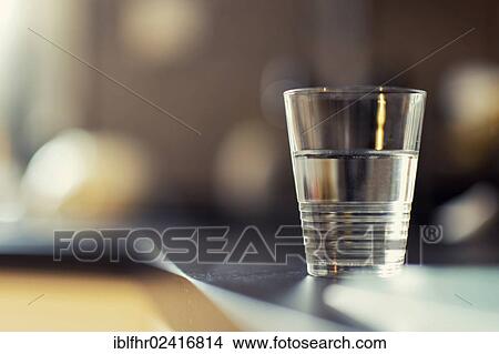 A half-full glass of water standing on a kitchen bench, Germany, Europe View Large Photo Image Picture - A half-full glass of water standing on a kitchen bench, Germany, Europe. Fotosearch