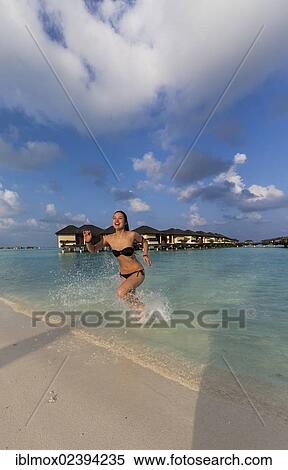 "A happy girl, about 19 years old, running on a beach, lagoon, Paradise Island at the back, Lankanfinolhu, North Male Atoll, Republic of Maldives, Indian Ocean, Asia" View Large Photo Image Stock Photography - "A happy girl, about 19 years old, running on a beach, lagoon, Paradise Island at the back, Lankanfinolhu, North Male Atoll, Republic of Maldives, Indian Ocean, Asia". Fotosearch
