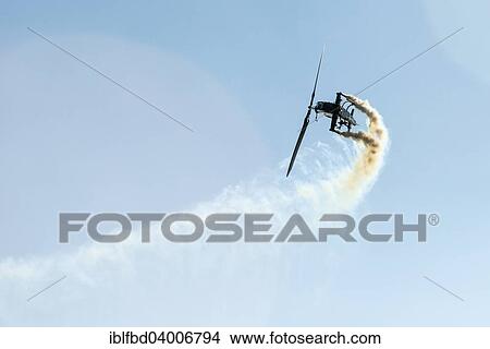 "A helicopter, releasing smoke, is performing stunts in the air, Zeltweg, Steiermark, Austria, Europe" View Large Photo Image Picture - "A helicopter, releasing smoke, is performing stunts in the air, Zeltweg, Steiermark, Austria, Europe". Fotosearch