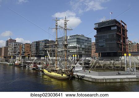 Stock Image - "A historic tall ship is moored in the Tall Ship Harbour, Traditionsschiffhafen harbour, modern residential and office buildings, Sandtorhafen harbour, Sandtorkai street, HafenCity, Hamburg, Hamburg, Germany, Europe". Fotosearch
