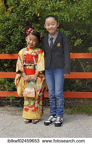 Stock Image - "A Japanese girl wearing a kimono and a Japanese girl wearing western clothing, Kyoto, Japan, East Asia, Asia". Fotosearch