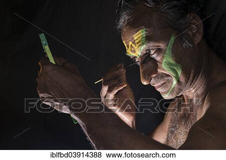 Stock Photo - "A Katakali artist is applying the make up of the character Arjun for the Kiritam play during a temple festival, Ayroor, Kerala, India, Asia". Fotosearch