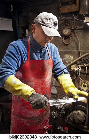 Stock Photo - "A knife seller sharpens a new blade at the Noryangjin Fish Market, Seoul, South Korea, Asia". Fotosearch