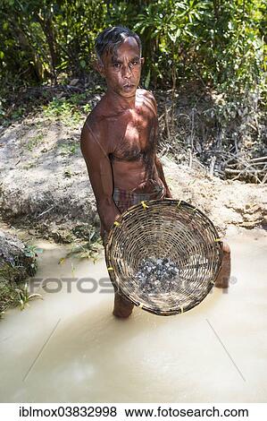 Stock Photo - "A labourer washing sand to win moonstones, Moonstone Mine, Nindana, Southern Province, Eranawila Region, Sri Lanka, Asia". Fotosearch
