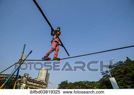 Stock Photography - "A little girl is balancing on a rope, Colaba, Mumbai, Maharashtra, India, Asia". Fotosearch
