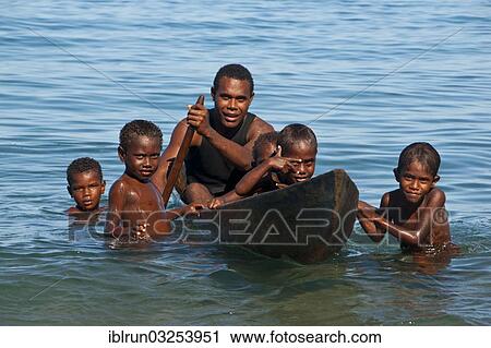Stock Image - "A man and children with a canoe, Savo Island, Central Province, Solomon Islands, Oceania". Fotosearch