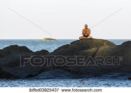 Stock Photo - "A man is meditating, practicing yoga on a rock, Kudle Beach, Gokarna, Karnataka, India, Asia". Fotosearch