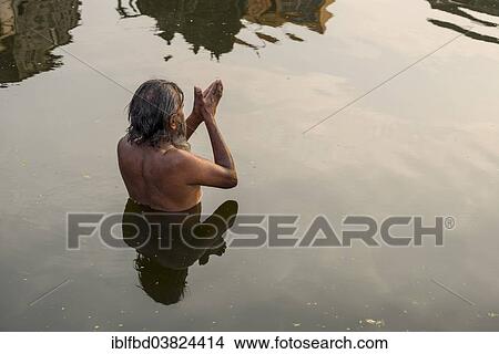 Picture - "A man is praying, standing in the holy waters of the river Godwari, Nasik, Maharashtra, India, Asia". Fotosearch
