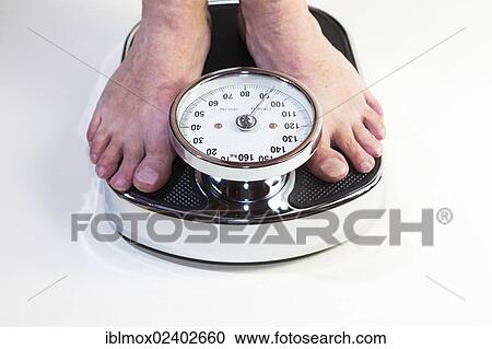 A man standing on bathroom scales View Large Photo Image Stock Image - A man standing on bathroom scales. Fotosearch