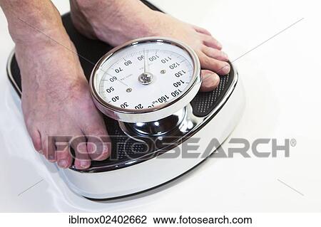 A man standing on bathroom scales View Large Photo Image Stock Image - A man standing on bathroom scales. Fotosearch