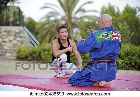 A martial arts instructor is giving instructions to a student during a training session in a park View Large Photo Image Stock Photo - A martial arts instructor is giving instructions to a student during a training session in a park. Fotosearch