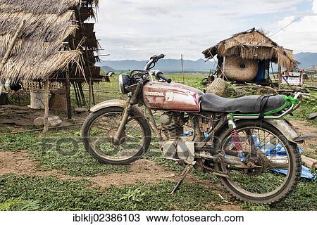 Stock Image - "A motorcycle and shelters in the dry lake bed at Doi Tao, Chiang Mai province, Thailand, Asia". Fotosearch