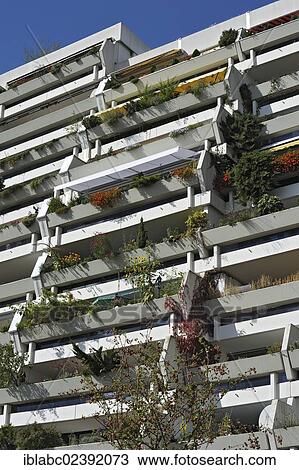 Stock Image - "A multistorey building with some plants on the concrete balconies, former Olympic Village, Munich, Bavaria, Germany, Europe". Fotosearch