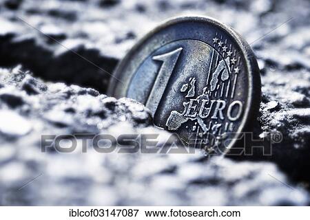 Stock Photo - "A one euro coin sticking in crevice, symbolic image for euro crisis, Germany, Europe". Fotosearch