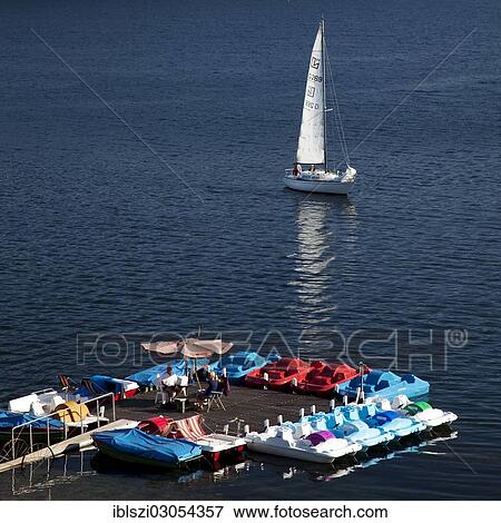 "A sailing boat near a pedalo boat hire on Sorpesee Lake or Sorpe Dam, Langscheid, Sundern, Sauerland, North Rhine-Westphalia, Germany, Europe" View Large Photo Image Stock Photo - "A sailing boat near a pedalo boat hire on Sorpesee Lake or Sorpe Dam, Langscheid, Sundern, Sauerland, North Rhine-Westphalia, Germany, Europe". Fotosearch