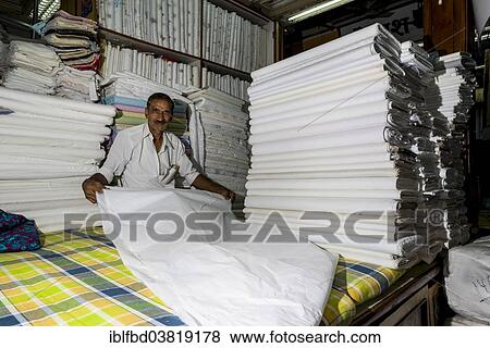 Stock Photo - "A salesman is displaying white material at Mangaldas Market, Mumbai, Maharashtra, India, Asia". Fotosearch