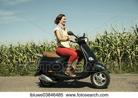 "A smiling woman driving with her scooter through fields, Mannheim, Baden-Wurttemberg, Germany, Europe" View Large Photo Image Stock Photography - "A smiling woman driving with her scooter through fields, Mannheim, Baden-Wurttemberg, Germany, Europe". Fotosearch