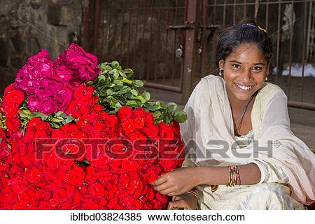 "A smiling young woman in a white sari is selling red roses at the weekly market, Nasik, Maharashtra, India, Asia" View Large Photo Image Stock Photography - "A smiling young woman in a white sari is selling red roses at the weekly market, Nasik, Maharashtra, India, Asia". Fotosearch