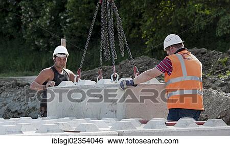 "A structural engineer and a worker are placing blocks during a building site load test, at a construction site in Fridolfing, Bavaria, Germany, Europe" View Large Photo Image Stock Photograph - "A structural engineer and a worker are placing blocks during a building site load test, at a construction site in Fridolfing, Bavaria, Germany, Europe". Fotosearch