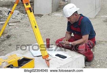 "A structural engineer is taking measurements of a possible soil dropping during a building site load test, at a construction site in Fridolfing, Bavaria, Germany, Europe" View Large Photo Image Stock Photography - "A structural engineer is taking measurements of a possible soil dropping during a building site load test, at a construction site in Fridolfing, Bavaria, Germany, Europe". Fotosearch