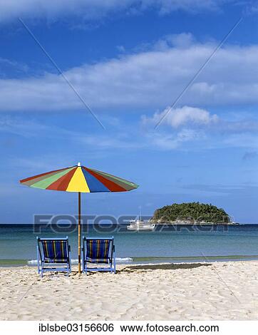 "A sunshade with two beach chairs on Kata Beach, and excursion boat and the island of Ko Pu at the back, Andaman Sea, Phuket, Phuket Province, Thailand, Asia" View Large Photo Image Stock Photograph - "A sunshade with two beach chairs on Kata Beach, and excursion boat and the island of Ko Pu at the back, Andaman Sea, Phuket, Phuket Province, Thailand, Asia". Fotosearch