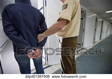 "A suspect being brought into a cell in police custody, re-enacted scene" View Large Photo Image Stock Photograph - "A suspect being brought into a cell in police custody, re-enacted scene". Fotosearch