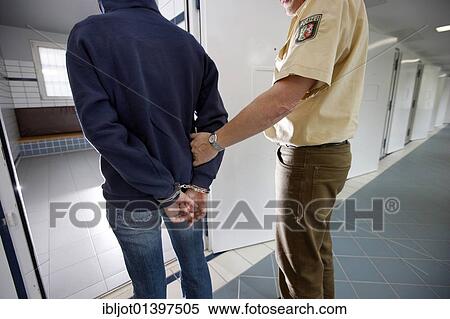 Stock Photography - "A suspect being brought into a cell in police custody, re-enacted scene". Fotosearch
