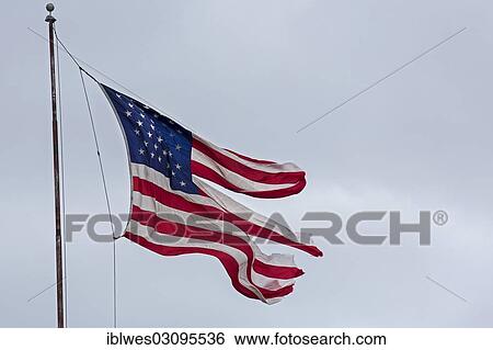 "A tattered US-American flag fluttering in the wind, Detroit, Michigan, United States, North America" View Large Photo Image Stock Photograph - "A tattered US-American flag fluttering in the wind, Detroit, Michigan, United States, North America". Fotosearch