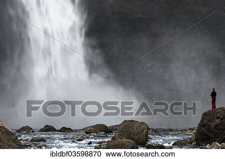 "A tourist is standing at the Haifoss waterfall on the Fossa i Thjosardal river, Thjorsardalur valley, Southern Region, Iceland, Europe" View Large Photo Image Stock Image - "A tourist is standing at the Haifoss waterfall on the Fossa i Thjosardal river, Thjorsardalur valley, Southern Region, Iceland, Europe". Fotosearch