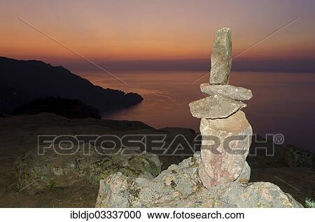 "A typical cairn in the Calanche of Piana in front of a colorful sunset sky illuminated by a flash unit. The Calanche of Piana is in the western part of the island Corsica, France, Calanques de Piana, Piana, Corsica, France, Europe" View Large Photo Image Stock Image - "A typical cairn in the Calanche of Piana in front of a colorful sunset sky illuminated by a flash unit. The Calanche of Piana is in the western part of the island Corsica, France, Calanques de Piana, Piana, Corsica, France, Europe". Fotosearch