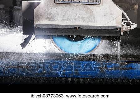 Stock Image - A wet-cutting machine cutting a stone slab. Fotosearch