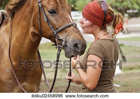 A woman calming her horse View Large Photo Image Stock Photograph - A woman calming her horse. Fotosearch