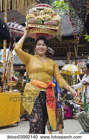"A woman carrying sacrficial offerings, at a temple ceremony, Pura Desa Temple, Ubud, Bali, Indonesia, Asia" View Large Photo Image Stock Image - "A woman carrying sacrficial offerings, at a temple ceremony, Pura Desa Temple, Ubud, Bali, Indonesia, Asia". Fotosearch